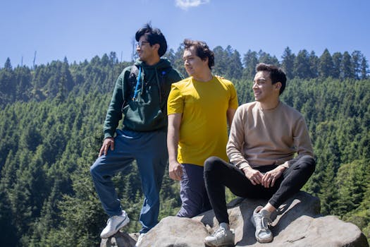 Three young adults enjoying a scenic outdoor adventure in a forested area under clear blue skies.