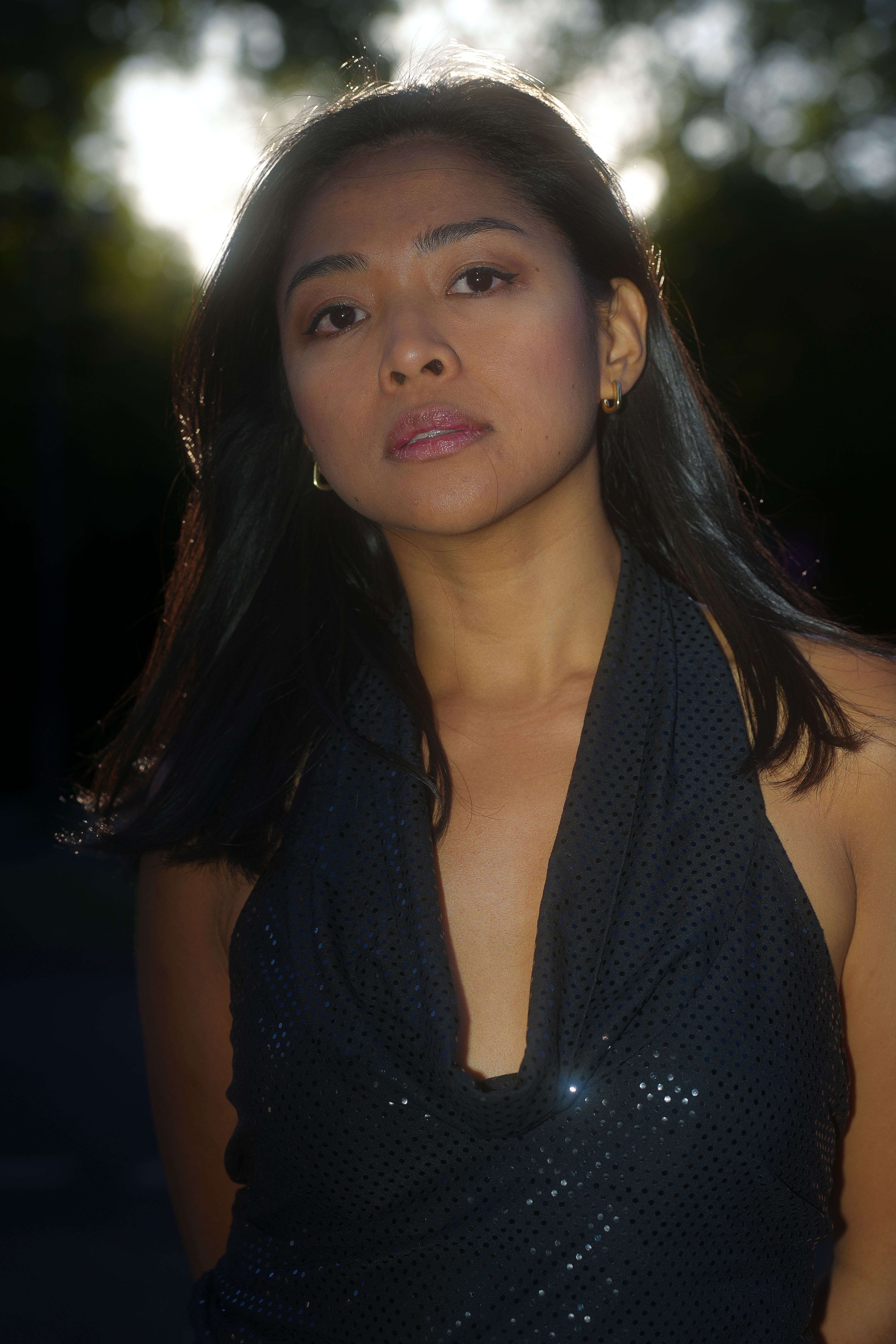 Elegant portrait of a woman in Berlin's golden sunlight, showcasing beauty and contrast.