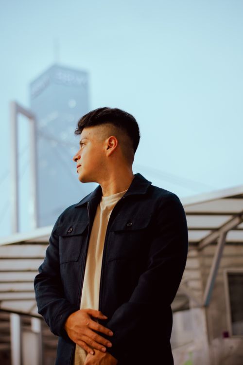 Free Young man in casual attire standing in front of tall building in Puebla, Mexico. Stock Photo