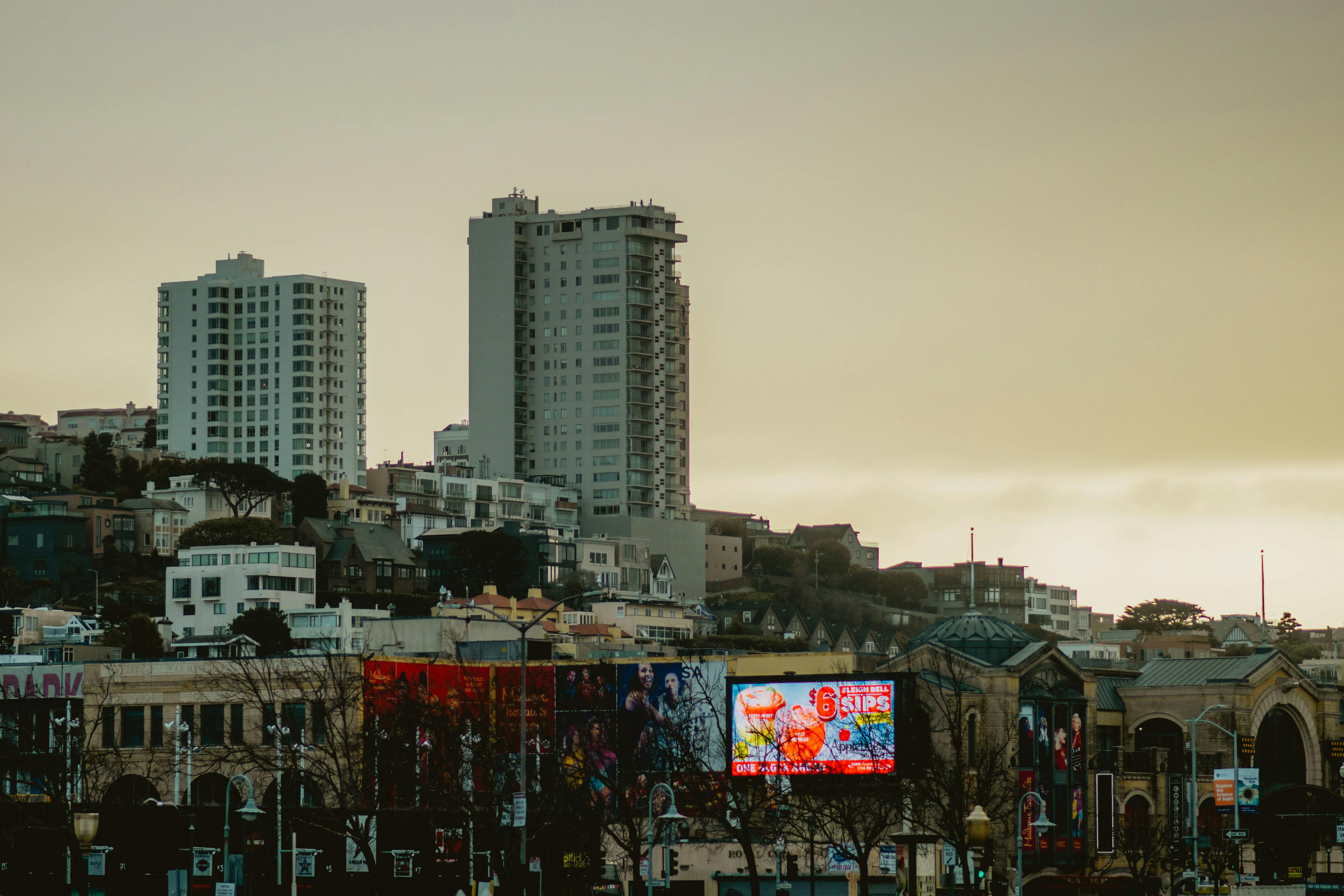 San Francisco skyline with prominent billboards during a calm dusk sky, showcasing urban architecture.