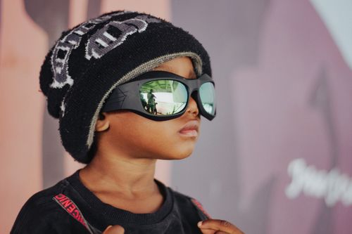 Free A young child wearing a cool beanie and reflective sunglasses, showcasing style and attitude. Stock Photo