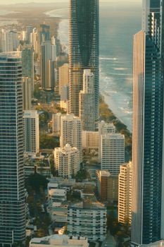 Stunning aerial view of skyscrapers by the ocean, capturing urban architecture and coast at twilight.