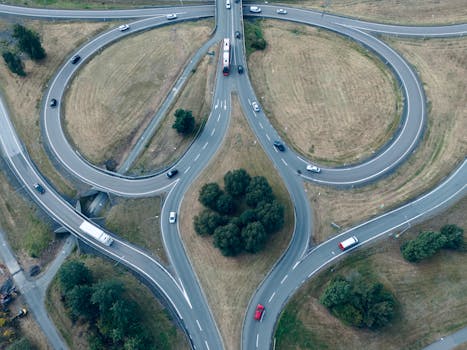 Drone shot of a highway interchange in Jönköping, Sweden, showing roads, vehicles, and green spaces.