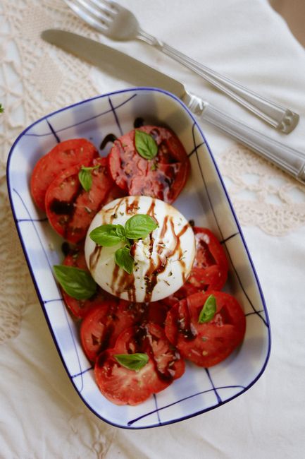 Caprese salad with burrata, tomatoes, basil, and balsamic glaze on a plate.