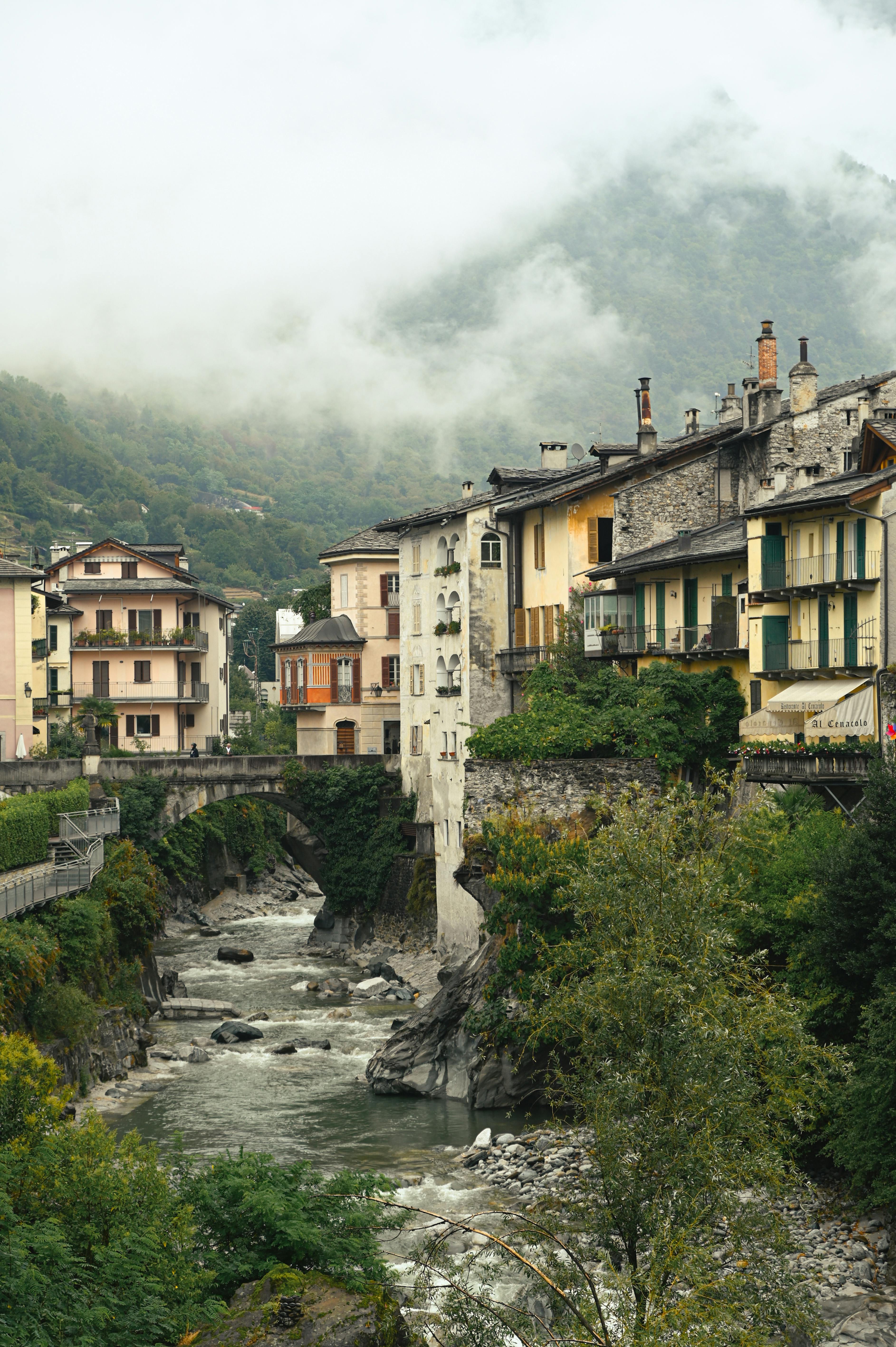 Picturesque Swiss village featuring historic architecture and a stone bridge over a flowing river.