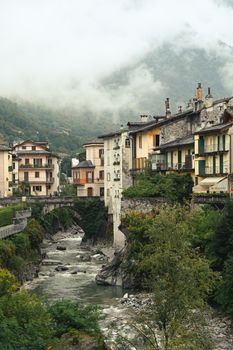 Picturesque Swiss village featuring historic architecture and a stone bridge over a flowing river.