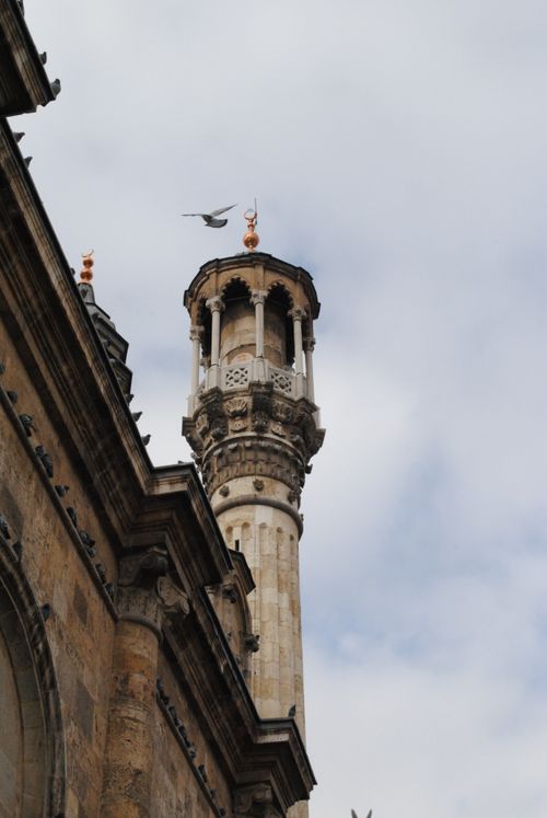 Free Aerial view of a historic minaret in Konya, Türkiye with a bird flying close by. Stock Photo