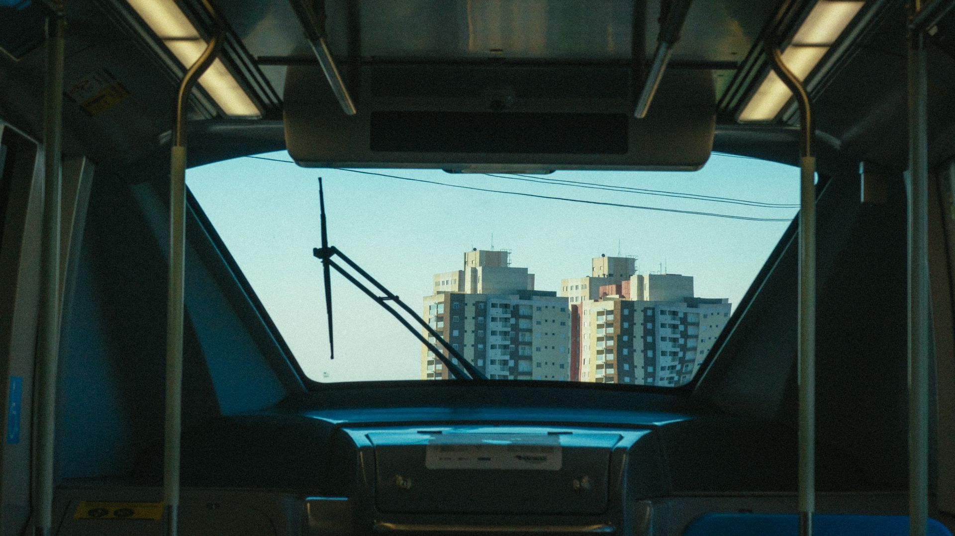 Inside a subway train with city buildings visible through the front window.