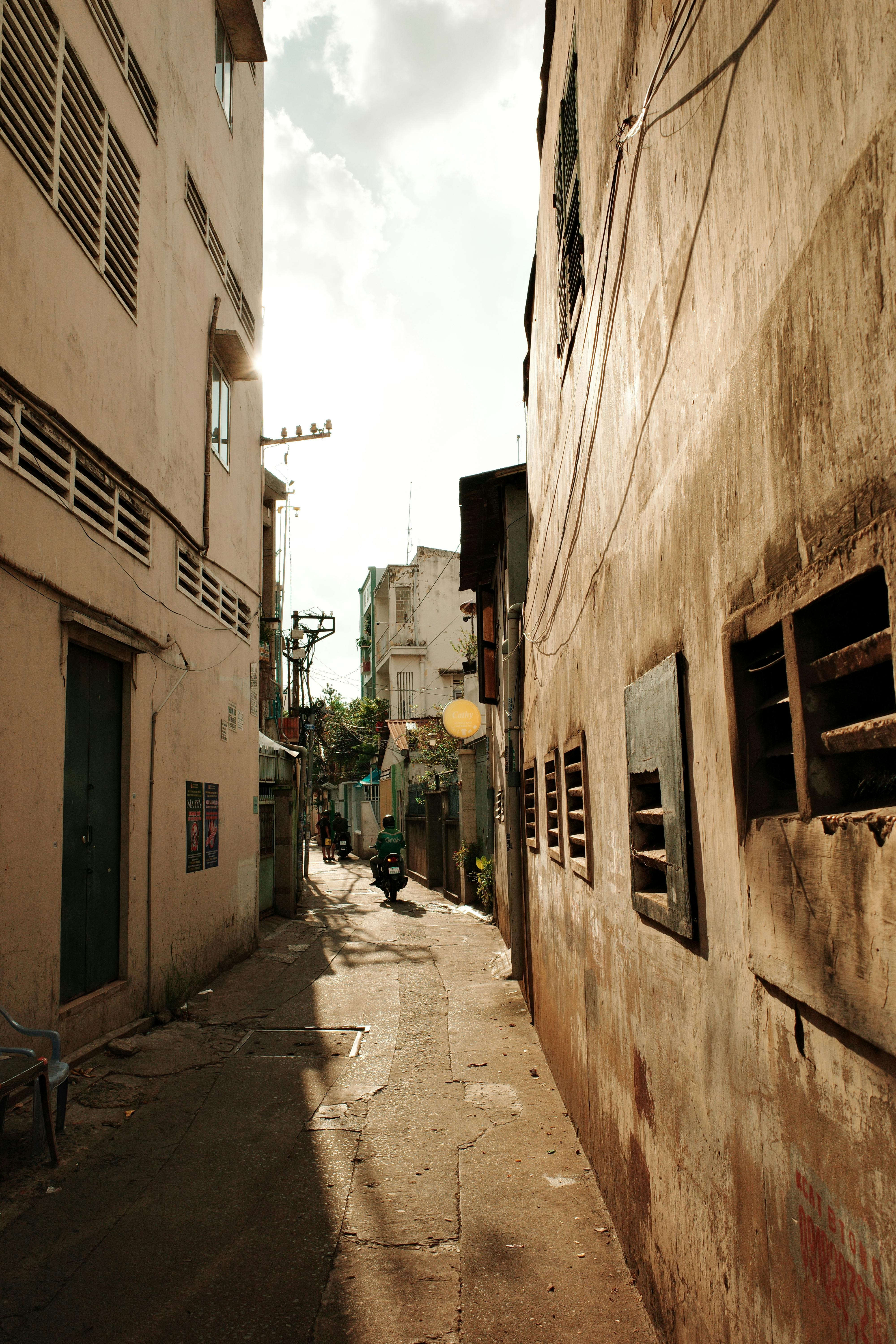 A candid street scene in a narrow alleyway in Ho Chi Minh City showcasing urban life.