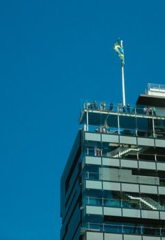 人们在晴朗的蓝天下建造现代建筑的屋顶观景台