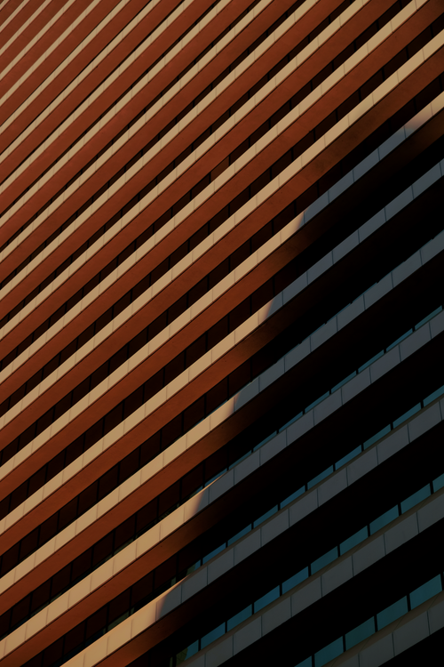 Free Striking architectural facade with minimalistic design and dynamic light and shadow contrast. Stock Photo