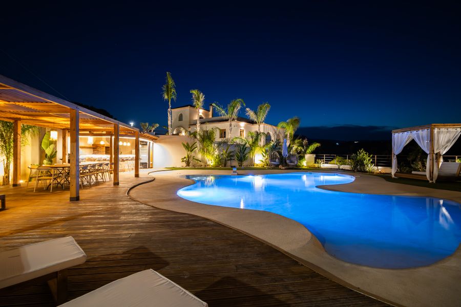 Villa illuminée autour de la piscine de nuit