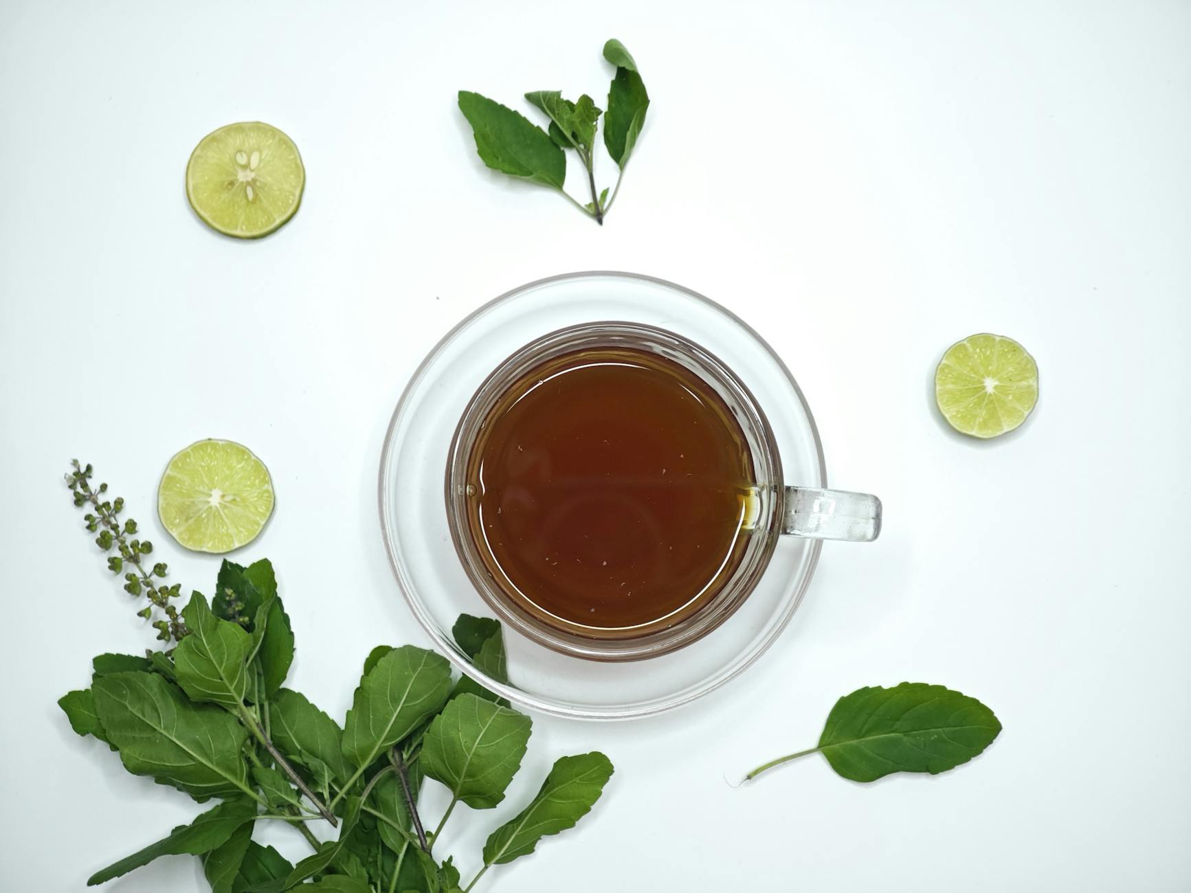Tulsi Tea In A Cozy Setting With A Steaming Cup, Surrounded By Fresh Tulsi Leaves And A Calming Nighttime Atmosphere