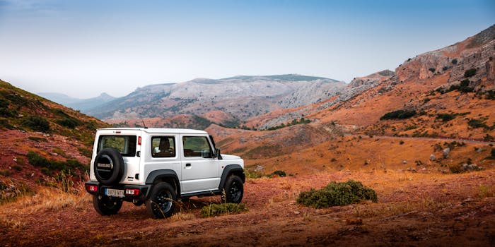 A white off-road vehicle parked in a scenic, rugged mountain terrain, showcasing adventure and exploration.