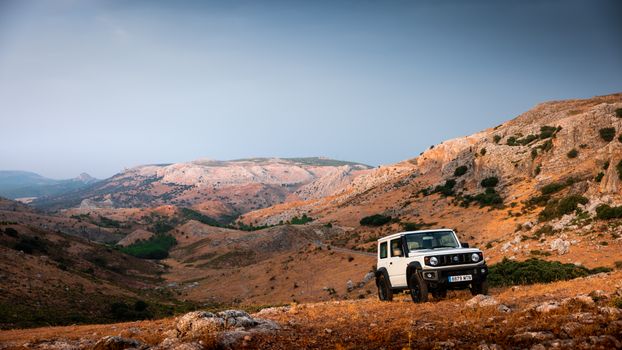 White SUV on a rugged mountain landscape during the day, perfect for adventure travel themes.