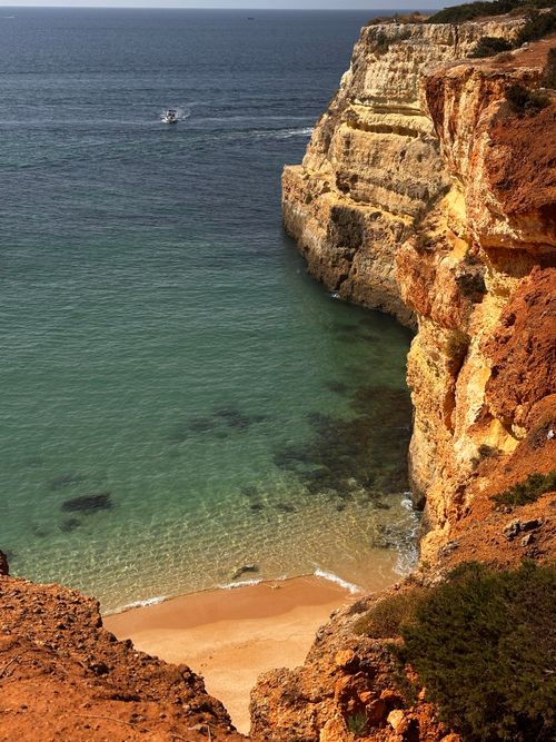 Free Stunning view of rugged cliffs and a serene sandy beach by the ocean, perfect for travel inspiration. Stock Photo