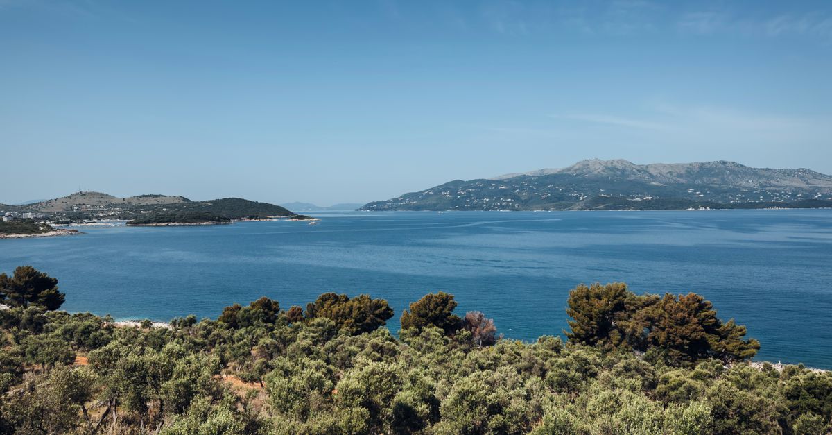 The Albanian Riviera coastline, green hillsides dropping to clear water