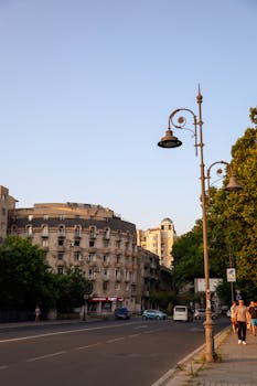 Charming city street at sunset with vintage lamp posts and historic architecture.