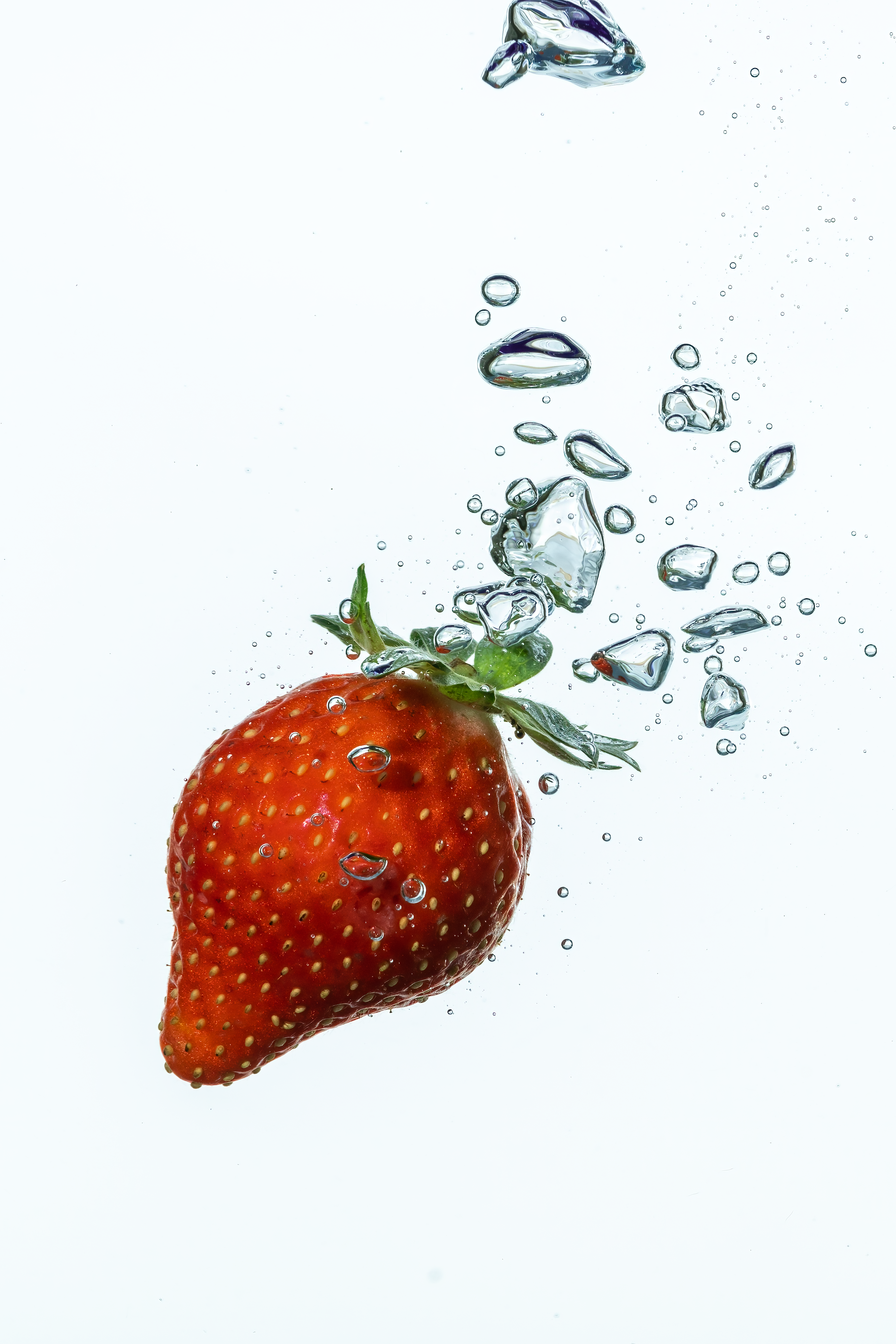 Fotomural Una fresa roja vibrante salpica agua clara con burbujas.