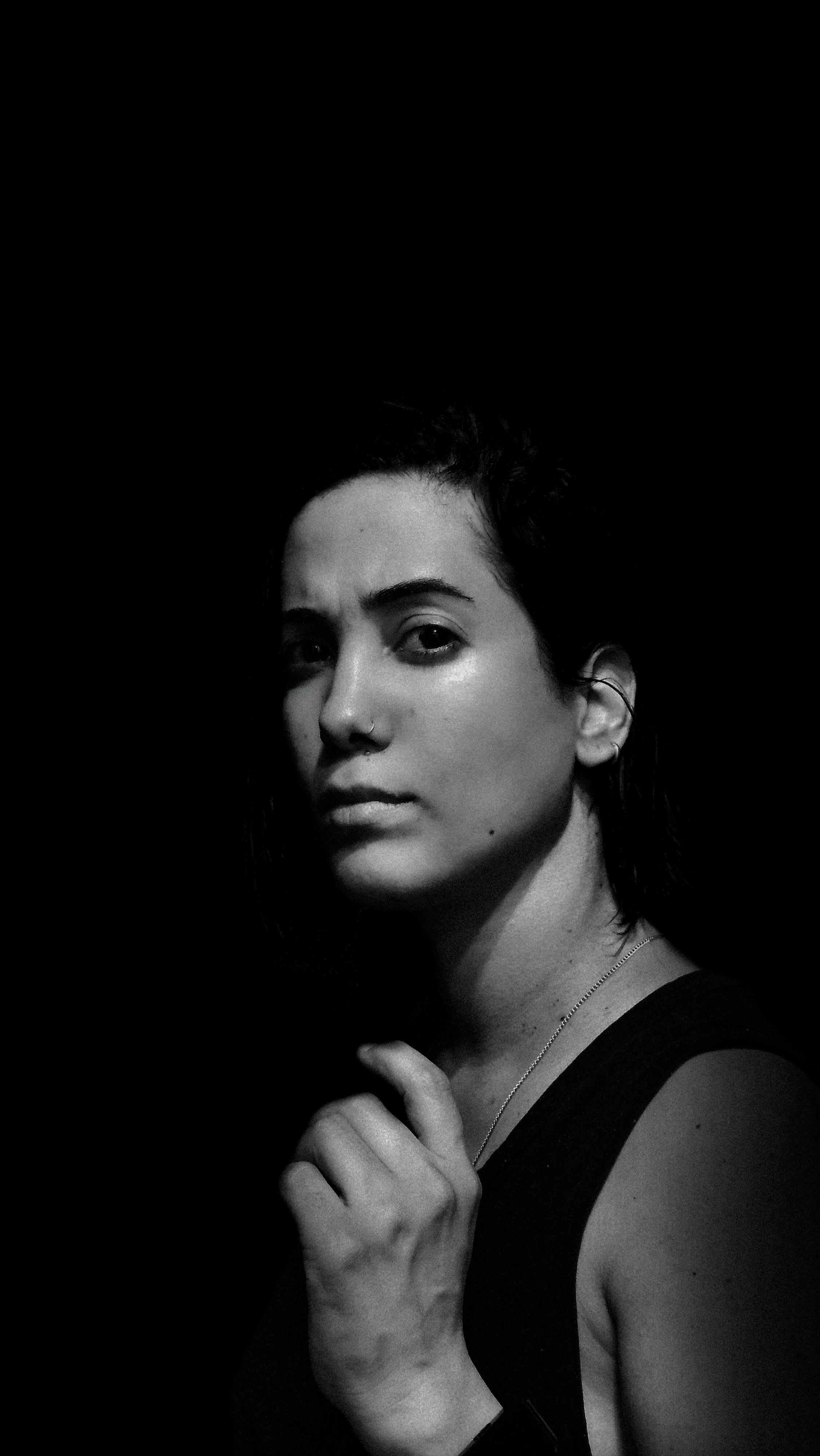 Black and white portrait of a woman with dramatic lighting, intense expression.