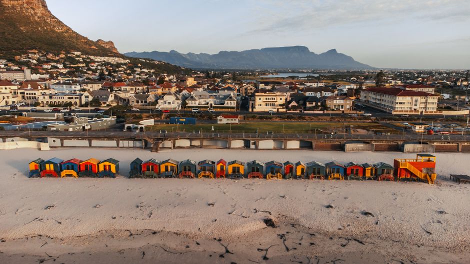 Amazing Two Oceans Helicopter Tour in Cape Town Review: Soaring Above Africa's Most Stunning Peninsula Review 2026 - Aerial view of vibrant beach huts on Muizenberg Beach with Cape Town skyline in the background.
