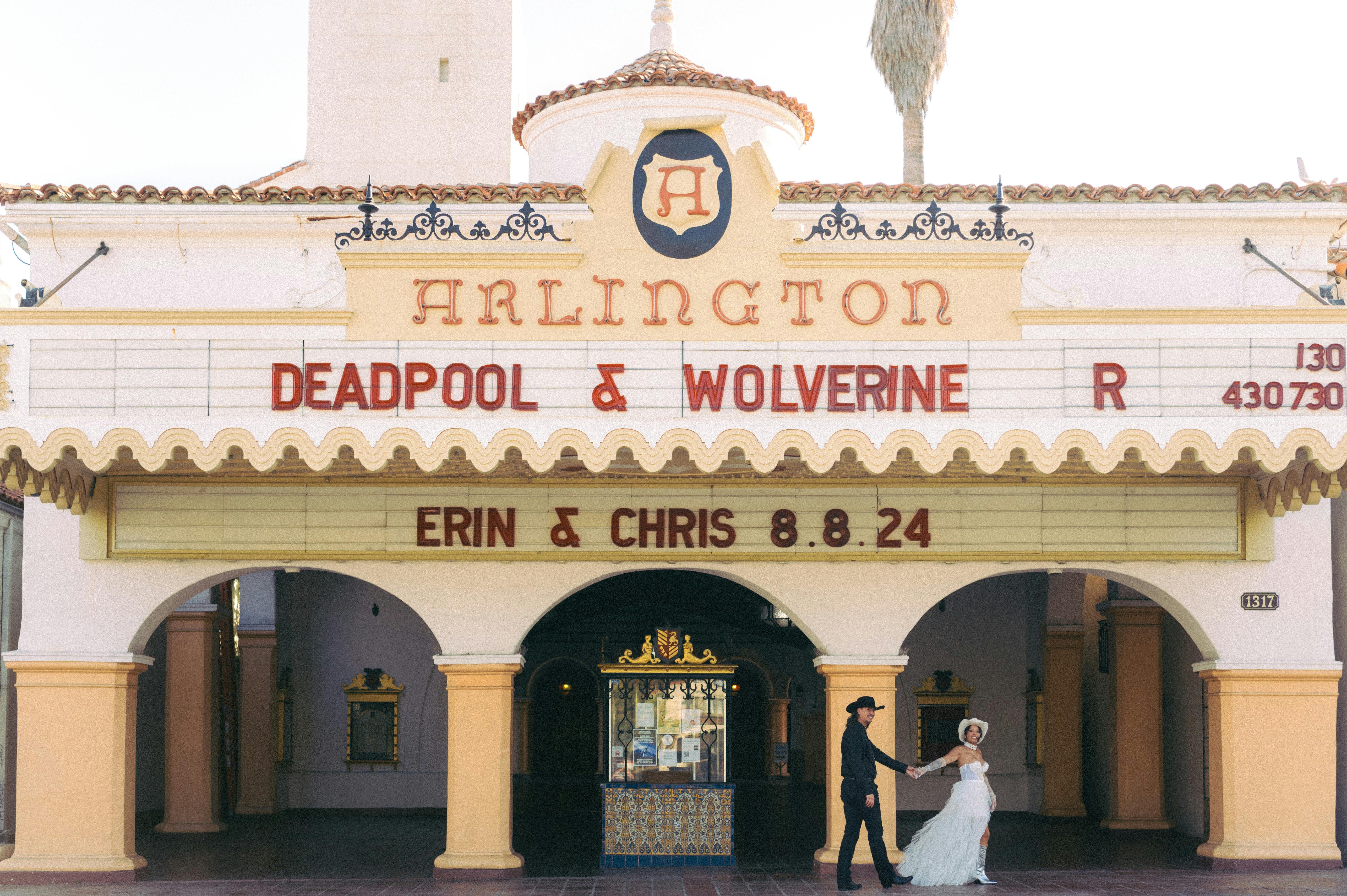 Gratis Brudeparet poserer foran Arlington Theater under et livlig og klassisk telt. Arkivbilde