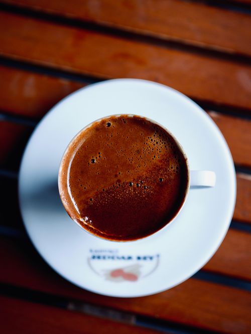 Free Rich Turkish coffee served in white cup and saucer on wooden table. Stock Photo