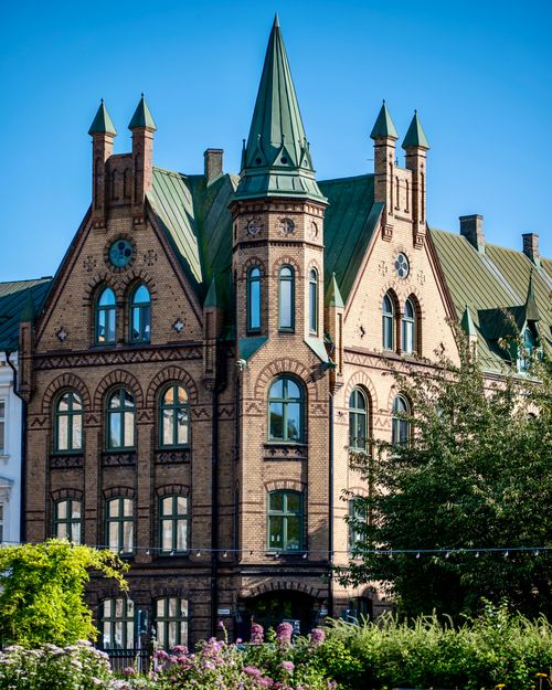 Free Gothic Revival building in Landskrona, featuring distinct architectural details and a summer sky. Stock Photo