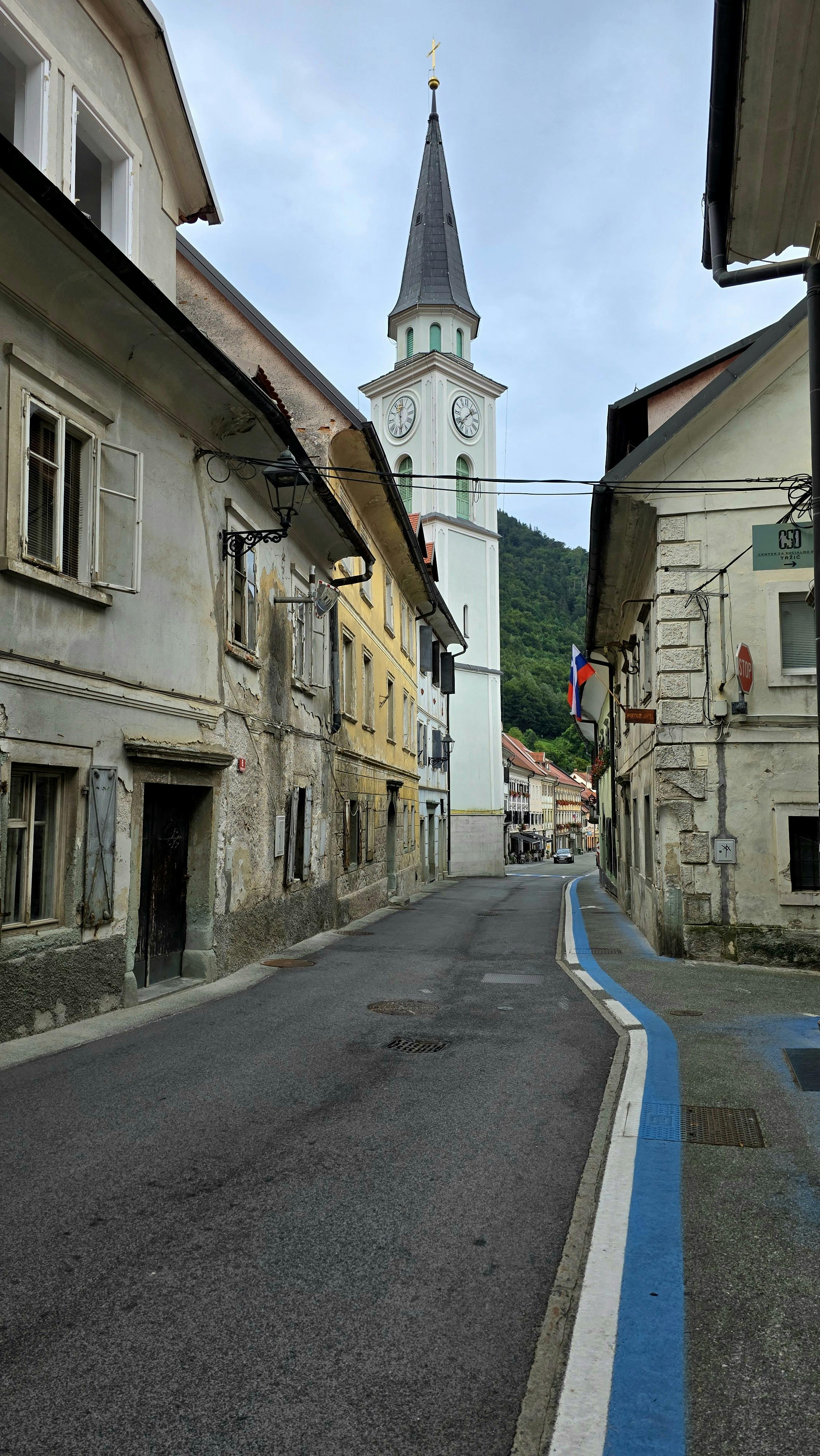 Charming street scene featuring a towering church spire in a picturesque European town.