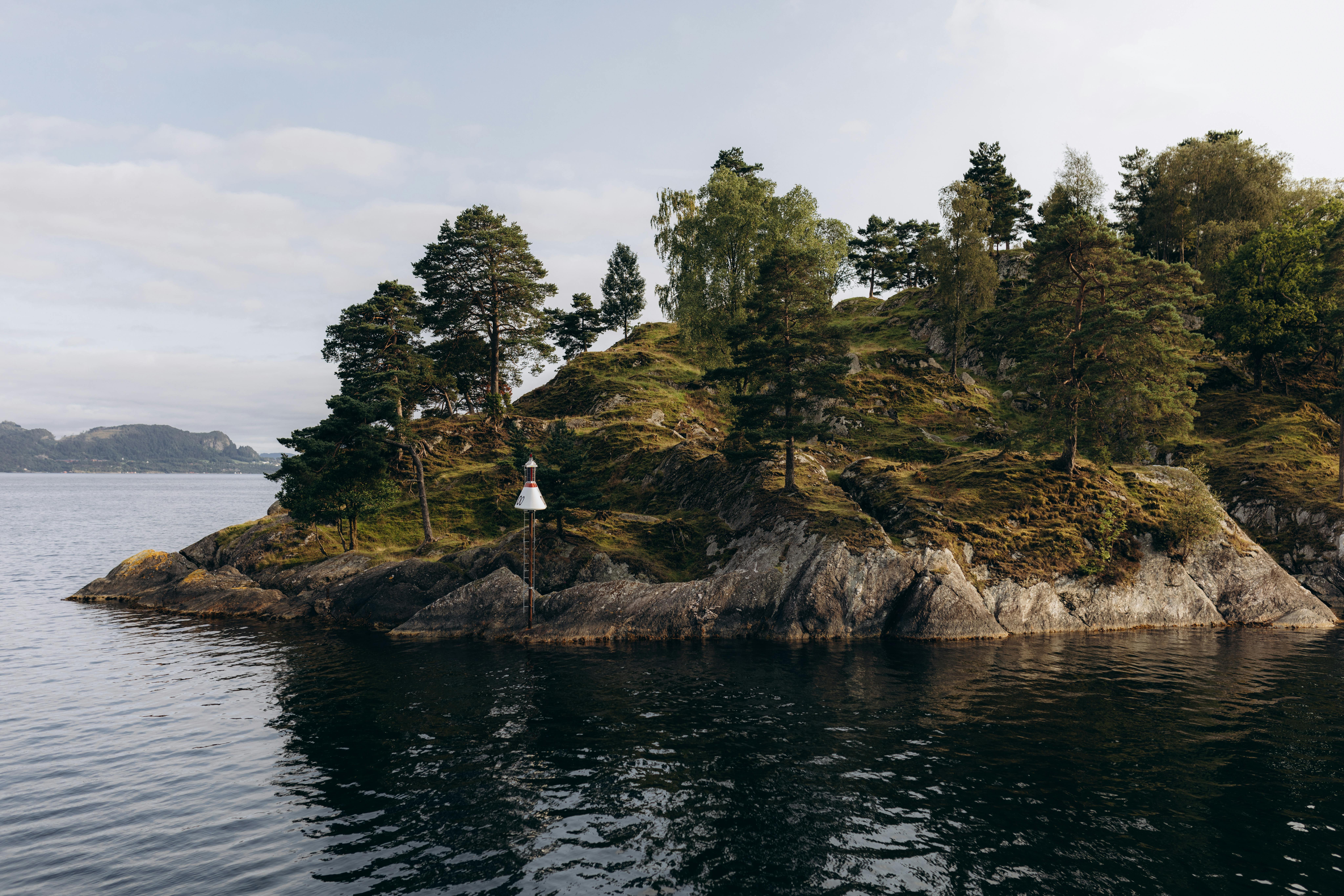 A serene view of a tree-covered island in the fjords near Bergen, Norway.