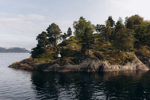 A serene view of a tree-covered island in the fjords near Bergen, Norway.