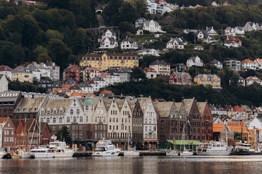 Scenic view of Bryggen and hillside houses in Bergen, Norway on a cloudy day.
