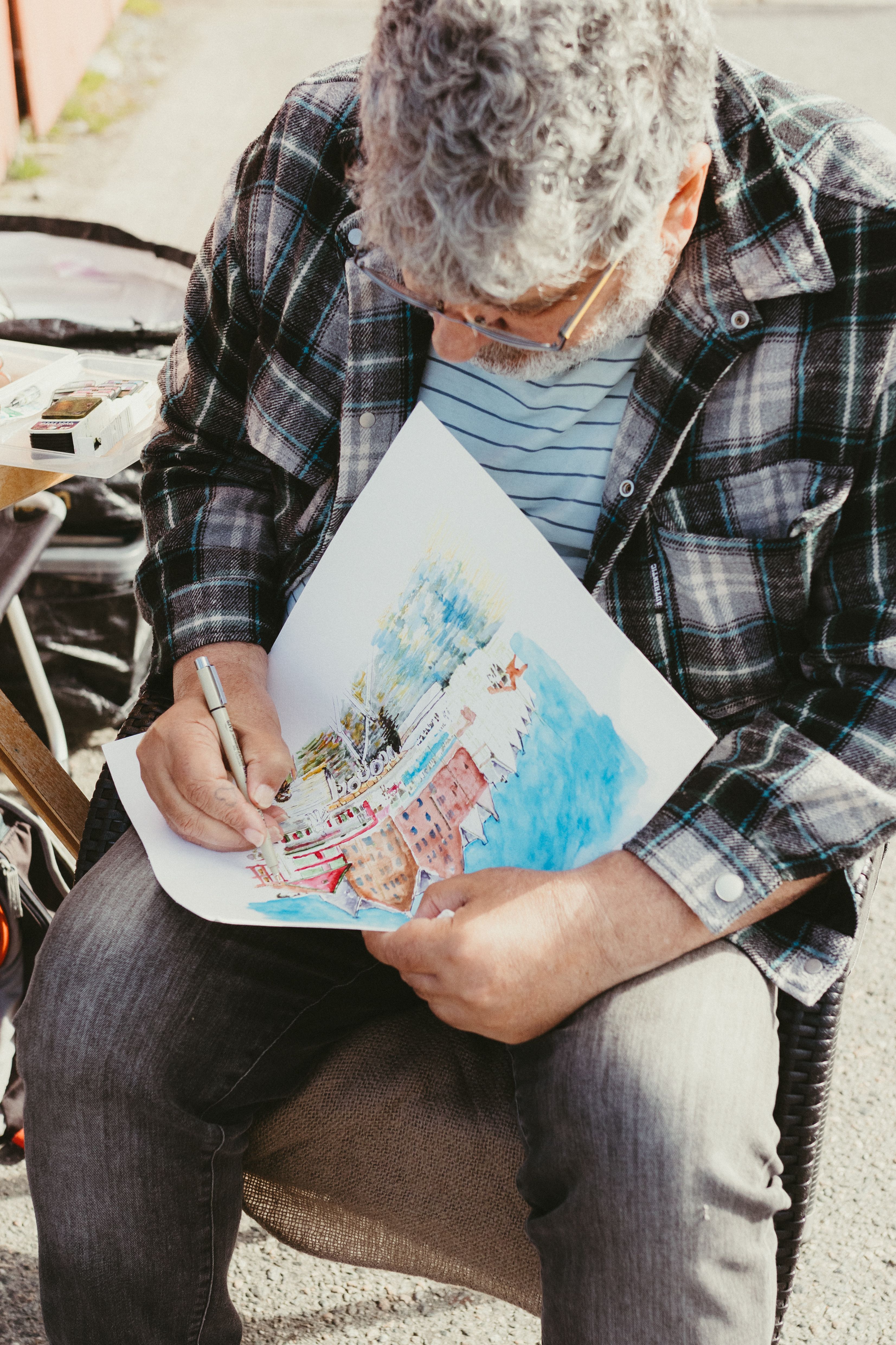 Man sketching scenic view in Bergen, Norway, outdoors in daylight.