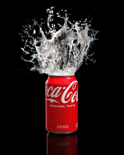 Free Coca Cola can with dramatic water splash effect, shot in a studio setting. Stock Photo