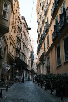 Charming narrow street in a European city with historical buildings and pedestrians.