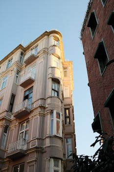 Classic architectural view of sunlit building corner against blue sky.
