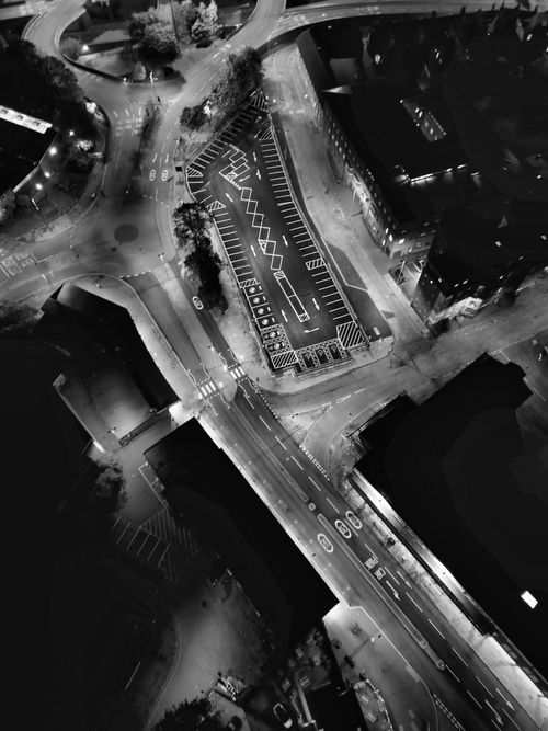 Free Black and white aerial photo capturing intricate urban street patterns illuminated at night. Stock Photo