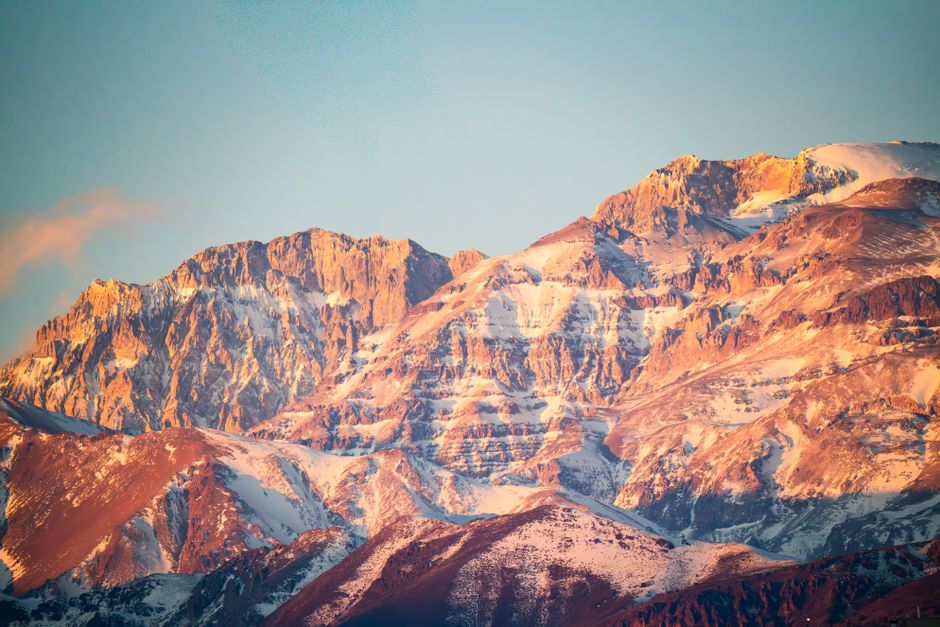 Captivating view of the Andes mountains near Santiago, Chile, glowing under a golden sunset.