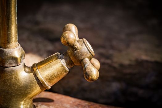 Detailed shot of an old brass faucet handle with rustic texture.