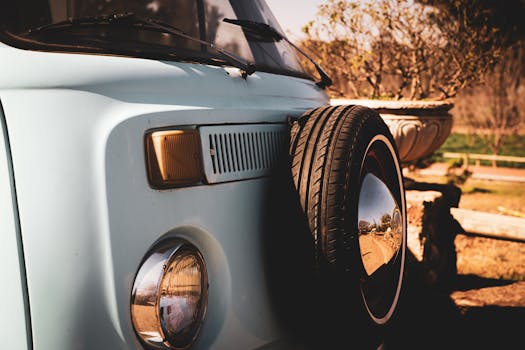 Close-up of a classic Volkswagen van with a spare tire, outdoors in warm, sunny light.