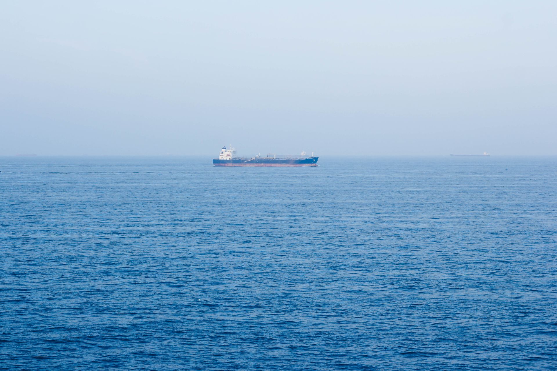 A large cargo ship sails on the tranquil ocean near Vũng Tàu, Vietnam, symbolizing global commerce.
