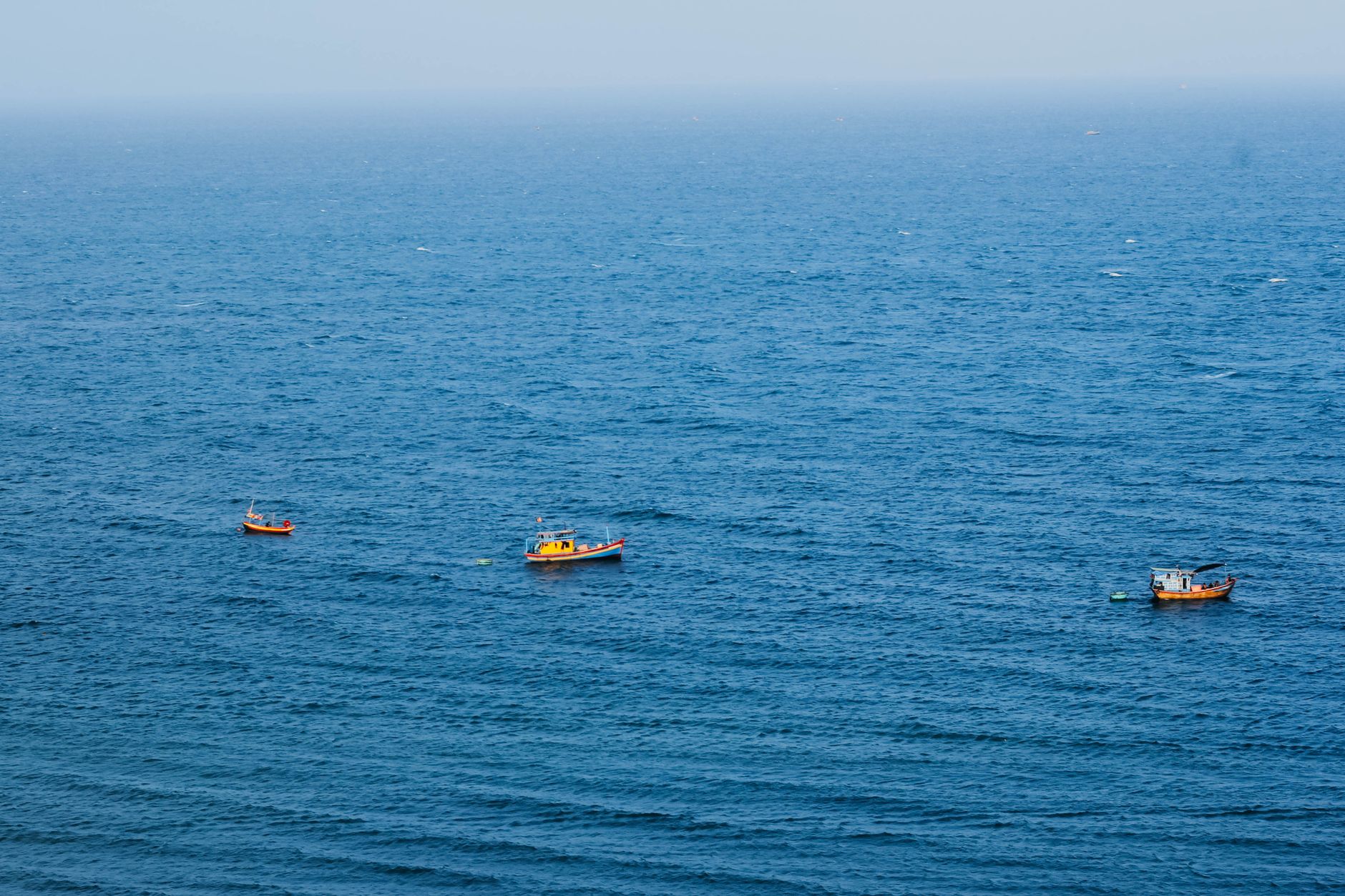 Aerial view of fishing boats in Vũng Tàu, Vietnam's Adriatic coast, serene seascape.