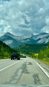 A picturesque mountain road under a dramatic cloudy sky, ideal for travel themes.