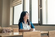 Thoughtful Student in Classroom Near Window