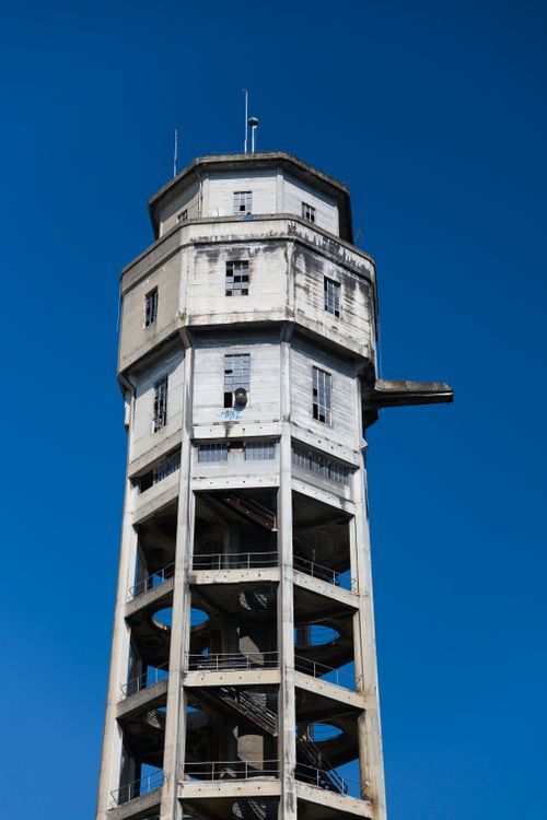 Free A striking view of a historic water tower set against a vibrant clear blue sky, showcasing its architectural design. Stock Photo