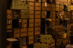 A dimly lit room filled with vintage security deposit boxes and keys, evoking mystery.