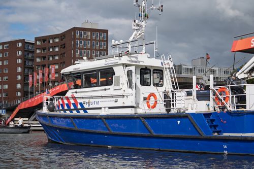 Free A Dutch police boat in a city canal, with urban buildings in the background. Stock Photo