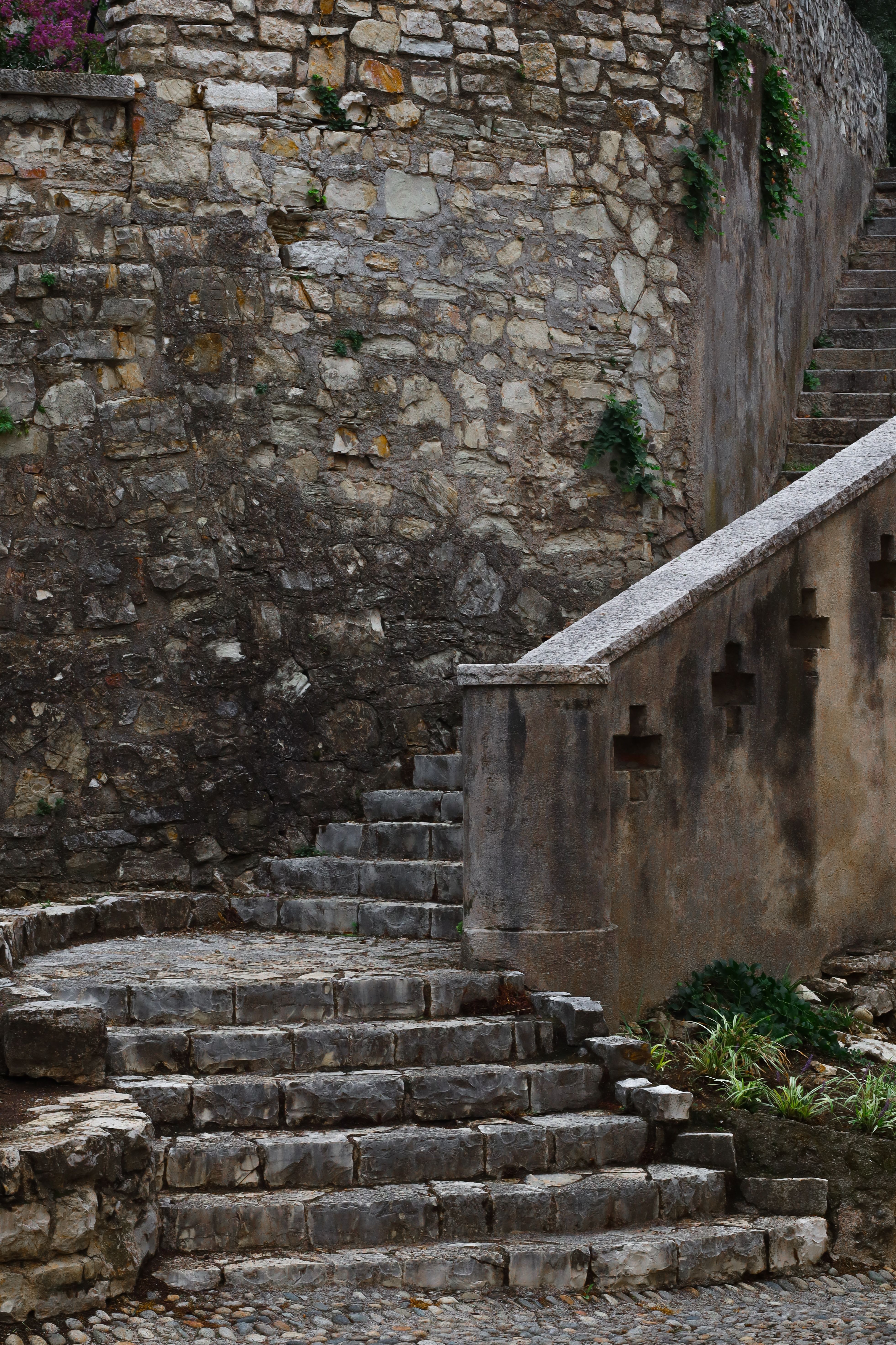 Escalier de pierre en courbe et mur de moellons, garde-corps de pierre percé de croix.