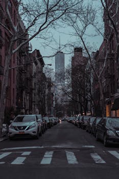 纽约市的夜晚，汽车在摩天大楼的背景下排成一行