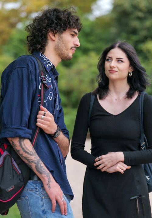 Free A young couple having a serious discussion outdoors, captured in a natural park setting. Stock Photo